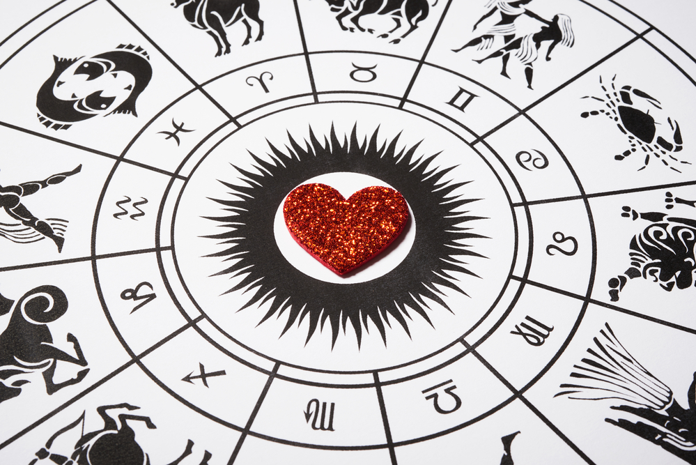Corazón rojo de purpurina de goma eva sobre una imagen de los signos del zodíaco en blanco y negro - El Templo de Gala -Tarot
